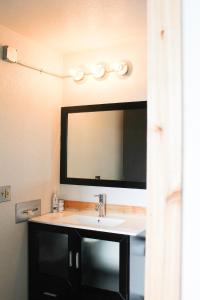 a white sink sitting under a mirror in a bathroom at Adrift Hotel in Long Beach