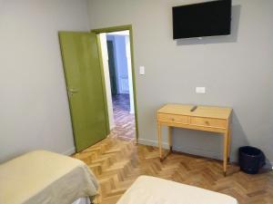 a room with two beds and a table and a television at Estepa Hotel in General Roca