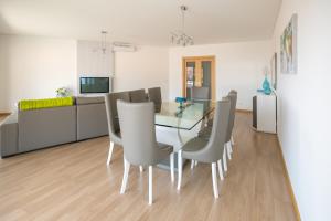 una sala da pranzo con tavolo in vetro e sedie di Casa dos Filhos by Rent2U, Lda a Funchal