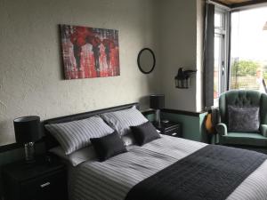 een slaapkamer met een bed en een groene stoel bij Southcroft in Bridport
