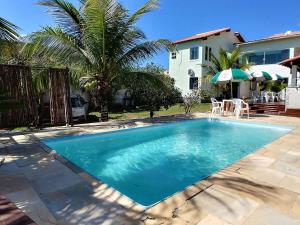 a swimming pool in front of a house at Pousada Santa Monica in Saquarema