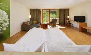 ein Hotelzimmer mit 2 Betten und einem Wohnzimmer in der Unterkunft Landhotel Wilder Mann in Eggingen