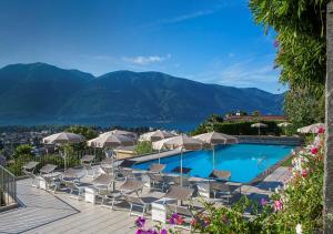 a beach with a pool and a balcony overlooking the ocean at Hotel Ascona in Ascona