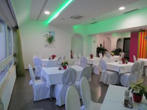 un salón de banquetes con mesas blancas y sillas blancas en Hotel Ballet School en Kaštela