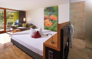 a bedroom with a bed and a living room at Landhotel Wilder Mann in Eggingen