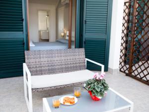 a white bench on a patio with a table with food at Villa Ulivi B&B in Pontecagnano