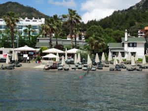 a resort with chairs and umbrellas on a beach at Beachwood Villas in Marmaris