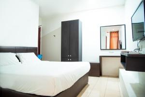 a bedroom with a large bed and a television at Shuang Ling Inn in Miri