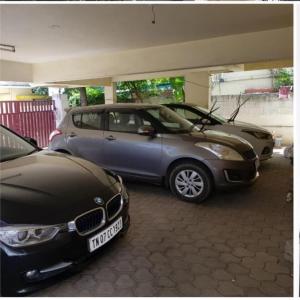dwa samochody zaparkowane obok siebie w garażu w obiekcie ROYALE ACHAYA w mieście Ćennaj