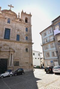una iglesia con coches estacionados frente a un edificio en Vitoria Apartments, en Oporto