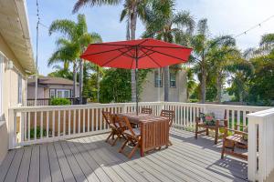 卡爾斯巴德的住宿－Ultimate Beach Bungalow - 1 block from beach - huge backyard，甲板上配有一张带红伞的木桌