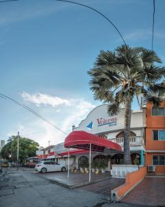 un edificio con una palmera en un aparcamiento en Hotel Veleros Cartagena, en Cartagena de Indias