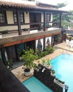 an external view of a building with a swimming pool at Hotel Pousada Laje de Itauna in Saquarema