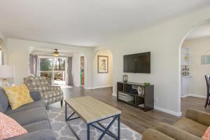 sala de estar con sofá y TV en Ultimate Beach Bungalow - 1 block from beach - huge backyard, en Carlsbad