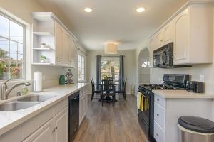 a kitchen with a sink and a stove top oven at Ultimate Beach Bungalow - 1 block from beach - huge backyard in Carlsbad