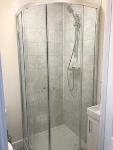 La salle de bains est pourvue d'une douche avec une porte en verre. dans l'établissement The Straw Bear, à Whittlesey