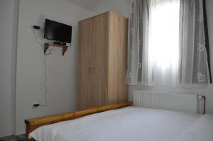a bedroom with a bed and a tv and a window at Green House in Kolašin
