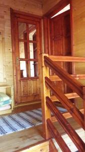 an empty room with wooden stairs in a log cabin at Hunor-Magor Vendégház in Izvoare