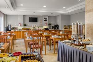 restauracja z drewnianymi stołami i krzesłami oraz stołówka w obiekcie Exe Getafe w mieście Getafe