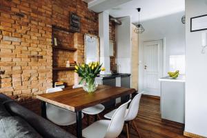 a dining room with a brick wall and a wooden table and chairs at Apartamenty Europa in Toruń