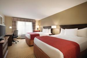 a hotel room with two beds and a television at Country Inn & Suites by Radisson, Des Moines West, IA in Clive