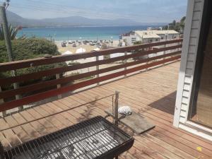 a balcony with a bench on a deck with the beach at Casa de playa Los Molles 833 in Los Molles