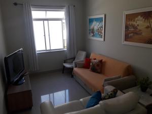 sala de estar con sofá y TV en Apartamento Praia do Forte, en Cabo Frío