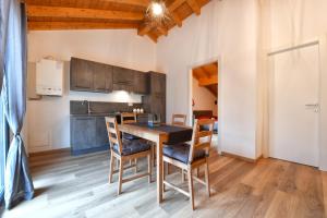 een keuken en eetkamer met een houten tafel en stoelen bij Il Gelsomino in Ornavasso