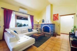 Una sala de estar con un sofá blanco y una chimenea. en casa mira Vivienda vacacional, en Güime