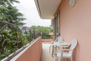 un balcone con due sedie, un tavolo e una finestra di io e te a Desenzano del Garda