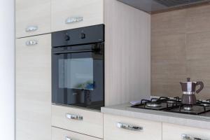 una cucina con piano cottura nero e forno di io e te a Desenzano del Garda