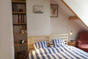um quarto com uma cama com lençóis listrados em azul e branco em Au coeur de soissons 1 em Soissons