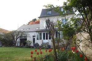 Uma casa branca com tulipas vermelhas à frente. em Au coeur de soissons 1 em Soissons