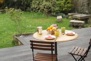 a table with a bowl of fruit on a deck at Au coeur de soissons 1 in Soissons