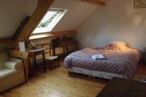 um quarto com uma cama, uma secretária e uma janela em Au coeur de soissons 1 em Soissons