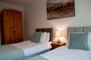 a bedroom with two beds and a painting on the wall at Bolton Executive Apartment in Bolton