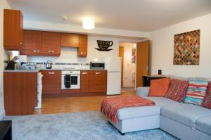 a living room with a couch and a kitchen at Bolton Executive Apartment in Bolton