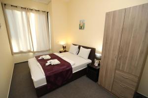 a bedroom with a bed with two towels on it at Hotel California in Budapest