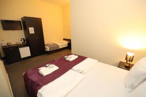 a hotel room with a bed with towels on it at Hotel California in Budapest