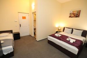 a bedroom with two beds with stuffed animals on them at Hotel California in Budapest