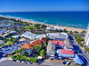 eine Luftblick auf einen Strand mit Häusern und das Meer in der Unterkunft Coolum Beach Resort in Coolum Beach