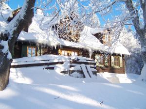 dom pokryty śniegiem z ławką przed nim w obiekcie Chata Pod Koberštejnem w mieście Rejvíz
