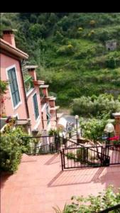 un groupe de maisons avec une clôture devant dans l'établissement Affittacamere Alle 5 Terre, à Monterosso al Mare