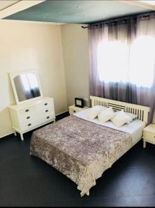 a bedroom with a bed and a tv and a window at Safiote House appartement in Safi