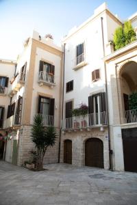 un grand bâtiment blanc avec balcon et cour dans l'établissement Ta Maison Bari, à Bari