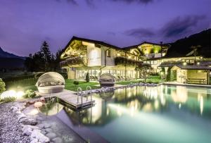 a mansion with a swimming pool at night at Adults Only Boutique-Hotel Unterlechner in Sankt Jakob in Haus