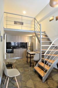 ネア・ポティダイアにあるSuite Loft Apartment Konstantinidisの階段、テーブル、椅子が備わるお部屋
