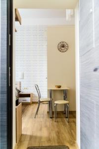 リヴィウにあるModern Studio Comfortのリビングルーム(テーブル、椅子、壁掛け時計付)