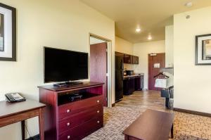 uma sala de estar com uma televisão de ecrã plano numa cómoda em Cobblestone Hotel & Suites - Gering/Scottsbluff em Gering