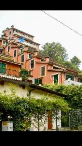 a large pink building with trees in front of it at Affittacamere Alle 5 Terre in Monterosso al Mare